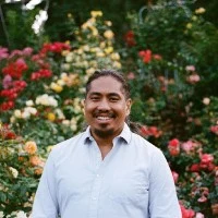 Michael Cruz in front of a rose garden